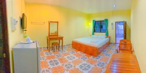 a bedroom with a bed and a table and a mirror at โชติอนุสรณ์ รีสอร์ท ชุมพร in Ban Bang Mak (1)