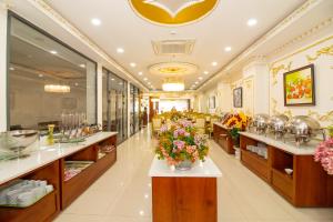 a restaurant with flowers on the counters and tables at Anh Thảo Hotel Quy Nhơn in Quy Nhon