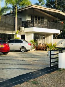 a white car parked in front of a house at Pinidiya Resort in Anuradhapura