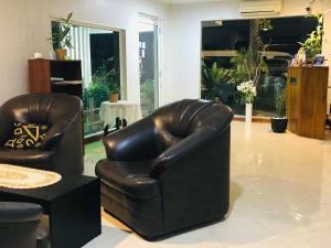 a living room with two leather chairs and a table at Pinidiya Resort in Anuradhapura