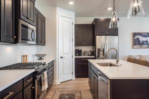 a kitchen with black cabinets and a sink and a stove at Desert Azul townhouse in St. George