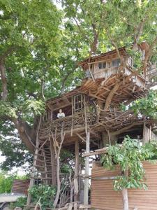Um homem está sentado numa casa na árvore. em Mizuno Sang's Tree House 