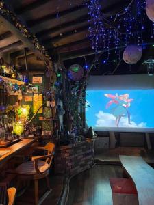 a bar with a large screen with a video game at Mizuno Sang's Tree House 