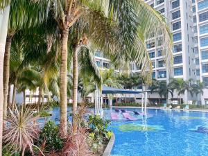 a swimming pool with palm trees in front of a building at NEW! Atlantis Residence I D1607 Premium 2BR I 5-10pax I Swing I JonkerSt I City Centre by Jay Stay in Melaka