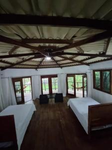 a large room with two beds and windows at Isla Cébaco in Isla Cebaco 
