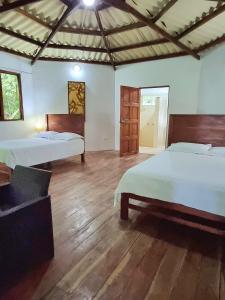 a bedroom with two beds and a wooden floor at Isla Cébaco in Isla Cebaco 