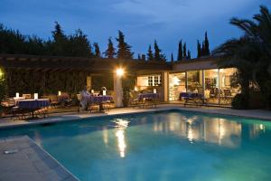 a swimming pool in front of a house at night at Saint-Vincent in Saint-Tropez