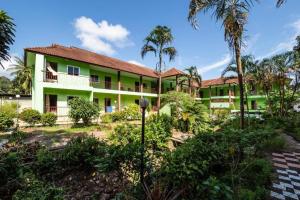 a green building with palm trees in front of it at Aree Resort in Ban Bang Bao