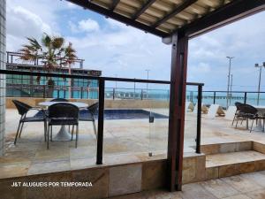 a patio with a table and chairs on top of a building at Tabajara flats in Fortaleza