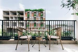 stół i 2 krzesła na balkonie w obiekcie La Maison De Fleurs w mieście Da Nang
