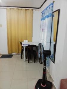 DaanbantayanにあるMatterhorn Guest Houseのテーブル、椅子、ファンが備わる客室です。