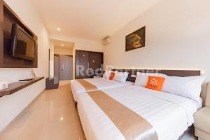 Voodi või voodid majutusasutuse Hotel Alqueby near Kiara Artha Park Mitra RedDoorz toas