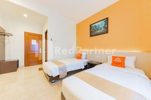 Voodi või voodid majutusasutuse Hotel Alqueby near Kiara Artha Park Mitra RedDoorz toas
