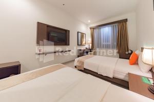 Voodi või voodid majutusasutuse Hotel Alqueby near Kiara Artha Park Mitra RedDoorz toas