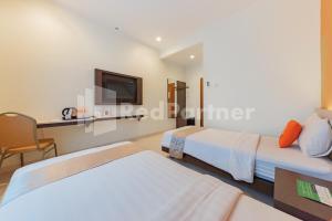 Voodi või voodid majutusasutuse Hotel Alqueby near Kiara Artha Park Mitra RedDoorz toas