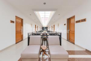 a corridor in a building with two chairs and a skylight at Hotel Alqueby Mitra RedDoorz in Bandung