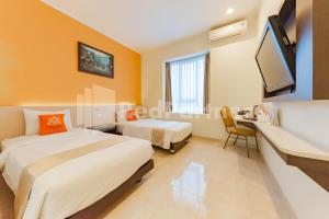 Voodi või voodid majutusasutuse Hotel Alqueby near Kiara Artha Park Mitra RedDoorz toas