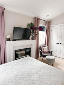 una camera con letto e camino con TV di Inn On King Bed & Breakfast a Niagara on the Lake