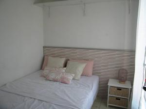 um quarto com uma cama com almofadas cor-de-rosa e brancas em Appartement Saint-Cyprien, 2 pièces, 4 personnes - FR-1-106-31 em Saint-Cyprien