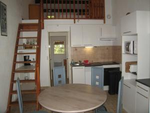 małą kuchnię ze stołem i drabiną w obiekcie Villa T3 Mezzanine Climatisée, Terrasse & Parking, 900m de la Plage - Saint-Cyprien Plage - FR-1-106-42 w mieście Saint-Cyprien