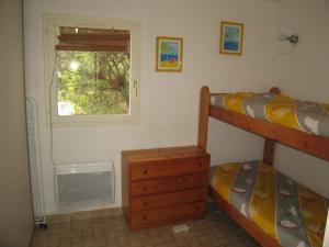 sypialnia z dwoma łóżkami piętrowymi i oknem w obiekcie Villa T3 Mezzanine Climatisée, Terrasse & Parking, 900m de la Plage - Saint-Cyprien Plage - FR-1-106-42 w mieście Saint-Cyprien