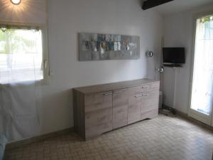 Pokój z komodą i telewizorem na ścianie w obiekcie Villa T3 Mezzanine Climatisée, Terrasse & Parking, 900m de la Plage - Saint-Cyprien Plage - FR-1-106-42 w mieście Saint-Cyprien