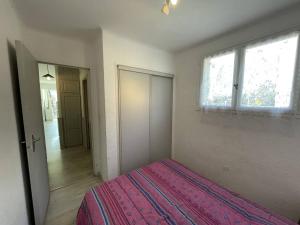 1 dormitorio con 1 cama con manta rosa en Appartement Saint-Cyprien, 2 pièces, 4 personnes - FR-1-106-30, en Saint-Cyprien