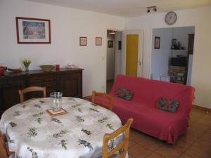 - un salon avec une table et un canapé rouge dans l'établissement Villa Saint-Cyprien, 4 pièces, 8 personnes - FR-1-106-33, à Saint-Cyprien
