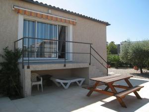 a patio with a table and a bench next to a house at Villa Saint-Cyprien, 4 pièces, 6 personnes - FR-1-106-40 in Saint-Cyprien