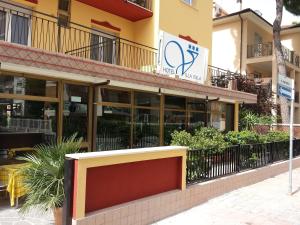 a building with glass windows and a restaurant at Hotel Villa Itala in Rimini