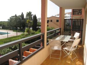 a balcony with a table and chairs and a pool at Appartement Saint-Cyprien, 3 pièces, 6 personnes - FR-1-106-44 in Saint-Cyprien