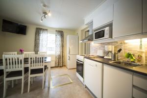 a kitchen with white appliances and a table and chairs at Kymppi in Rovaniemi