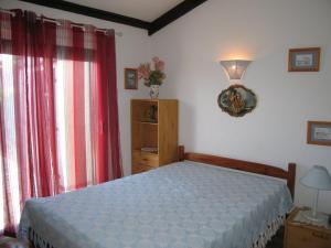 a bedroom with a bed and red curtains at Villa Saint-Cyprien, 3 pièces, 6 personnes - FR-1-106-57 in Saint-Cyprien