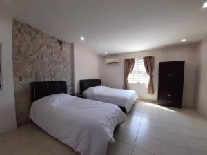 a hotel room with two beds and a window at Zing Motel in Butterworth