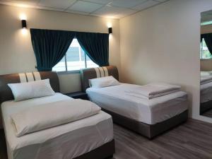 a hotel room with two beds and a window at Zing Motel in Butterworth