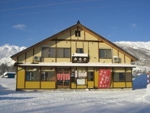 a building with a sign on it in the snow at Nagomi-tei in Hakuba