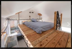 sypialnia z łóżkiem na drewnianej podłodze w obiekcie albiez-hoterement 