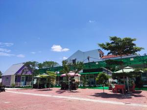 a group of buildings with tables and umbrellas at Zing Motel in Butterworth