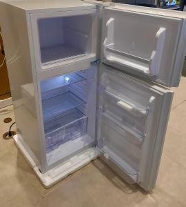 an empty refrigerator with its door open in a kitchen at SMDC Breeze Residences in Manila