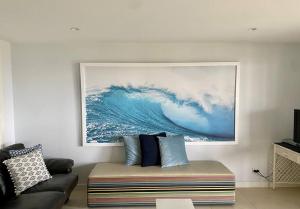 een woonkamer met een bank en een schilderij aan de muur bij Summer Salt Beach House in Ulladulla
