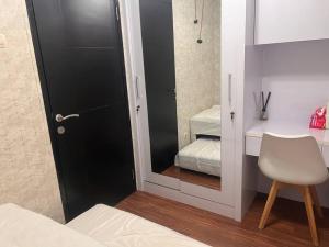sypialnia z lustrem, łóżkiem i krzesłem w obiekcie Apt Casablanca East 2BR With Netflix and Pool w Dżakarcie