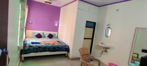 a bedroom with a bed with a purple wall at Alpha House Matheran in Matheran