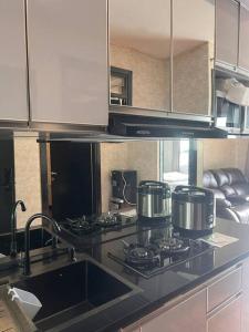 a kitchen with a sink and a stove top oven at Apt Casablanca East 2BR With Netflix and Pool in Jakarta