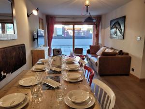 a table with plates and glasses on it in a living room at Confortable T4, terrasse, parking et Wi-Fi, au centre et proche pistes - FR-1-598-129 in Les Gets