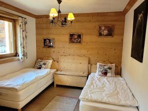 two beds in a room with wooden walls at Appartement spacieux 4 pièces, 3 ch., parking et WiFi, centre des Gets - FR-1-598-126 in Les Gets
