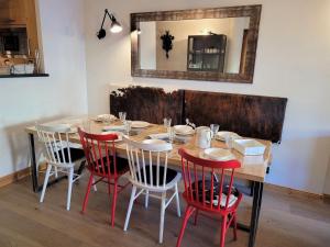 a dining room table with red chairs and a mirror at Confortable T4, terrasse, parking et Wi-Fi, au centre et proche pistes - FR-1-598-129 in Les Gets +8 photos