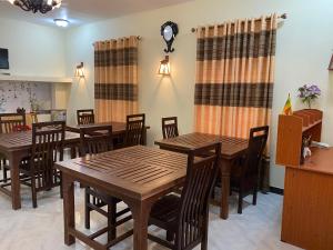 a dining room with wooden tables and chairs at Aurora View Inn in Haputale