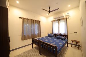 a bedroom with a bed and a ceiling fan at Le Pondy Home Stay in Pondicherry