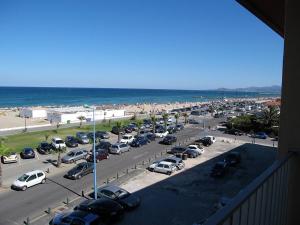 parking z samochodami zaparkowanymi na plaży w obiekcie Appartement T2 rénové, 4 couchages, parking, face plage, centre de Saint-Cyprien - FR-1-106-74 w mieście Saint-Cyprien