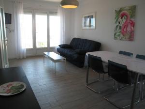 salon ze stołem i kanapą w obiekcie Appartement T2 rénové, 4 couchages, parking, face plage, centre de Saint-Cyprien - FR-1-106-74 w mieście Saint-Cyprien